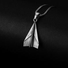 a silver origami necklace on a black background