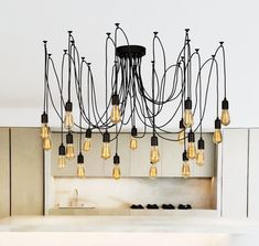 a chandelier with many lights hanging from it's sides in a kitchen