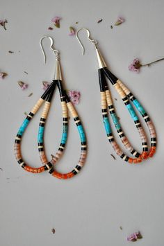 Native American double loop heishi earrings by artist Mary Calabaza (pink) Beautiful long heishi earrings with double loop in a colorful  combination of beads...black jet, melon shell, blue turquoise, pink shell and coral. By the talented Santo Domingo artist Mary Calabaza. The artist is using thread instead of wire for a more flexible look. Measurements : 3" long 3mm beads sterling silver cones and ear wire Jet, shell, turquoise and coral thread copper ring/bead with artist signature Nickel-free Multicolor Heishi Beads Jewelry, Artisan Dangle Earrings With Heishi Beads, Colorful Heishi Beads Dangle Jewelry, Handmade Heishi Bead Dangle Jewelry, Multicolor Heishi Beads Jewelry With Dangling Beads, Gift Heishi Bead Earrings, Heishi Earrings, Black Jet, Artist Signature