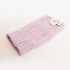 a pair of pink socks sitting on top of a white table next to a tag