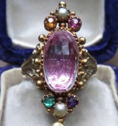 This beautiful Georgian ring is a real show stopper! Center stone is a genuine pink tourmaline set in 14k Yellow Gold with smaller paste stones surrounding it. Currently a size 7 but very easily sizable by any local jeweler. All questions are welcome! Thank you kindly. Antique Oval Multi-stone Ring, Exquisite Multi-stone Sapphire Ring, Oval Multi-stone Ruby Ring, Elegant Pink Multi-stone Sapphire Ring, Pink Oval Multi-stone Ruby Ring, Formal Pink Amethyst Ring With Gemstone Accents, Formal Pink Multi-stone Sapphire Ring, Formal Multi-stone Pink Ruby Ring, Elegant Pear-shaped Pink Ruby Ring