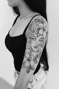 a woman with a tattoo on her arm and shoulder is shown in black and white