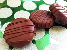 three pieces of chocolate sitting on top of a green and white polka dot tablecloth