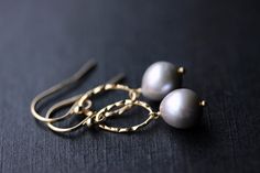 "Gorgeous gray, semi-baroque, freshwater pearl earrings. These beautiful gray pearls have amazing shine, are nearly blemish free, and have the most amazing deep lavender-gray hue. I have attached these pearls to a textured oval component; they hang from either sterling silver earwires or 14k gold filled earwires. Pearls measure 8.5mm. Overall length is 1\" Please select your preferred earring metal and style upon checkout. Your purchase will come securely packaged in a slate gray jewelry gift bo Elegant Nickel-free Gray Jewelry, Gray Pearl Drop Jewelry For Gift, Elegant Gray Earrings With Ear Wire, Elegant Gray Earrings As Gift, Elegant Gray Earrings For Gift, Handmade Elegant Gray Jewelry, Handmade Gray Elegant Jewelry, Elegant Handmade Gray Jewelry, Gray Jewelry