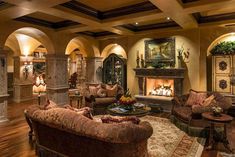 a living room filled with furniture and a fire place in the middle of a room