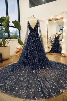 a dress on display in front of a mirror and potted plant with lights behind it