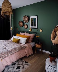 a bed room with a neatly made bed next to a plant and pictures on the wall