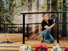 a woman sitting on the steps in front of flowers