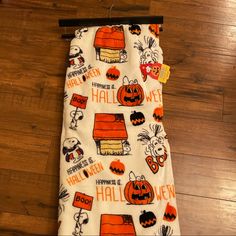 a halloween themed kitchen towel hanging on a wooden floor with the words happy halloween written all over it