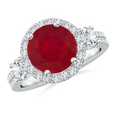 an oval ruby and diamond ring with three diamonds around the band, set in 18k white gold