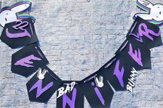 a purple and black kite with white writing on it that says happy new year hanging from the side of a brick wall