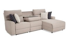 a beige sectional sofa with pillows on it