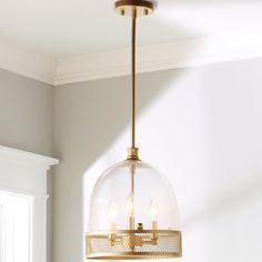 a light fixture hanging from the ceiling in a room with white walls and flooring