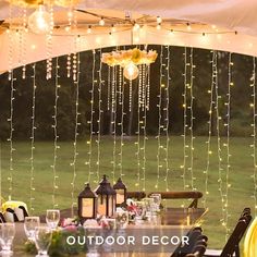 an outdoor dining area is decorated with string lights and lanterns