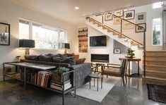 a living room filled with furniture next to a stair case