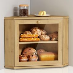 a wooden cabinet filled with bread and pastries