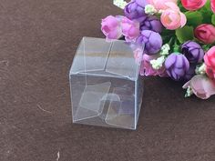 there is a clear plastic box with flowers in the corner and on the ground next to it