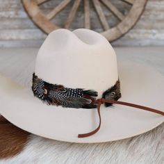 The Falcon Western Feather Hat Band boasts a width of 4 cm and an approximate length of 58 cm, excluding the leather ties. Designed to fit most sizes, this adjustable hat band features leather ties for a secure and comfortable fit. Please note that this product includes one single hat band and does not come with a hat. The feather detailing adds a bold touch of western flair, making it a distinctive addition to any hat. Adjustable Leather Fedora With Short Brim, Adjustable Wide Brim Felt Hat For Western-themed Events, Adjustable Brimmed Top Hat For Western-themed Events, Adjustable Western Style Brimmed Fedora, Adjustable Wide Brim Felt Hat For Rodeo, Adjustable Brimmed Country Style Felt Hat, Adjustable Brimmed Country Felt Hat, Adjustable Fedora For Western-themed Events, Adjustable Hat Bands For Country Events In Fall