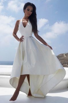 a woman in a white dress posing for the camera