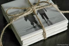 two people holding hands wrapped in twine on top of four small square coasters