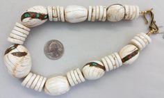 "The gorgeous white beads in this Tibetan necklace are fossilized shells. The pendant and the oval shell beads have been enhanced with inlay called Gak. Gak is a mixture of coral, turquoise, sometimes lapis, brass and sometimes copper. Sacred chank shell (Turbinella Pyrum Linne) has been revered for thousands of years, since at least 2000 B.C. Chank shell is revered in Tibet, India, Nagaland and China. It is used by Hindus and Buddhists in rites and religious ceremonies. Tibetan men and women we White Oval Beads Artisan Jewelry, Artisan White Oval Beads Jewelry, Artisan White Jewelry With Polished Beads, Southwestern Style White Beaded Necklace With Large Beads, Southwestern Style Large White Beads, White Jewelry With Natural Oval Stone Beads, White Jewelry With Natural Oval Beads, White Jewelry With Oval Natural Stones, Southwestern Style Hand-strung White Beads