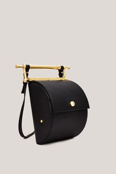 This is Thana. Handmade in Italy, using only the highest quality materials, Thana’s unique shape and gold-coated hardware make it an absolute stand-out. The brand’s signature decorative handle is undoubtedly unique, serving as both an intentional design detail and functional element to the bag. With an adjustable, removable strap the Thana can be styled cross-body, over the shoulder or as a chic handbag. Featuring our signature large interior compartment with pearl detail. Chic Handbags, S Signature, Custom Packaging, Saddle Bags, Inside Pocket, Design Details, Cross Body, Shoulder Strap, In Italy