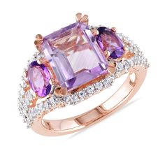 This elegant amethyst, Rose de France amethyst, and created white sapphire fashion ring will add a stunning pop of color to your style. Crafted in sterling silver with rose rhodium plating, this ring features at its center a large, emerald-cut Rose de France amethyst accented on either side by an oval, purple amethyst. Round, created white sapphires run across the top of the ring and down both sides to provide an extra touch of radiance. The corners are faceted on the Rose de France amethyst, ma Rose Gold Plated Ring, White Sapphire Ring, 3 Stone Rings, Men Ring, Zircon Ring, Gold Plated Rings, Sapphire Stone, White Sapphire, Amethyst Ring