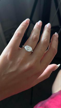 a woman's hand with a diamond ring on it