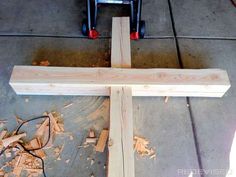 a wooden cross sitting on top of a floor