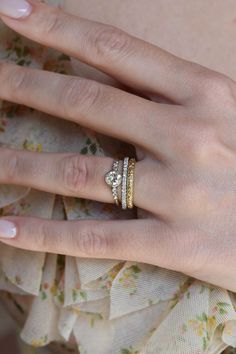 a woman's hand with three rings on it