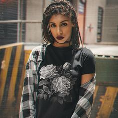 Introducing our striking black t-shirt adorned with a beautiful bouquet of roses! The stunning contrast of the vibrant black and white roses against the dark black background creates a bold and eye-catching design that's sure to turn heads for that dark gothic look. The design is printed with high-quality ink that's made to look faded and cracked to give it that worn look. But you can be sure that you'll be able to wear this t-shirt for years to come. The slim fit cut provides a modern, flattering silhouette that will look great on both men and women. The crew neck and short sleeves make this t-shirt perfect for layering, or wearing on its own during the warmer months. Order yours today and experience the beauty and sophistication of this stunning roses on a black or white t-shirt for your Cheap Black T-shirt With Rose Print, Black Short Sleeve T-shirt With Rose Print, Black Rose Print Short Sleeve T-shirt, Black Crew Neck T-shirt With Rose Print, Afro Goth, Black And White Roses, Fashion Romantic, Gothic Looks, Rose Shirts