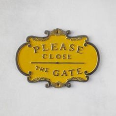 a yellow sign that says please close the gate on white paper with gold trimming