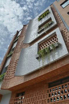 a tall building with many windows and plants growing on it