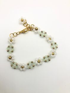 Looking for a piece of jewellery that exudes elegance and sophistication? Look no further than our sage green Rainflower bracelet! Crafted with the finest materials, this bracelet boasts stunning sage green gems and white glass flowers. The intricate design of this piece is truly mesmerizing, making it an ideal accessory for any occasion. Whether you're attending an upscale event or simply looking to add some flair to your everyday attire, this gorgeous Rainflower Bracelet is sure to make a stat Gold Flower-shaped May Birthstone Jewelry, Gold Flower Jewelry For May Birthstone, Elegant Green Beaded Bracelets With Flower Shape, Elegant Green Flower-shaped Beaded Bracelets, Gold Crystal Bracelet For May Birthstone Gift, Green Bracelet With Flower Charm As Gift, Green Beaded Bracelets With Flower Charm For Gift, Elegant Green Bracelet With Flower Charm, Dainty Green Jewelry With Flower Charm