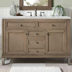 a bathroom vanity with a mirror above it and a rug on the floor next to it