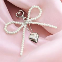 a bow with pearls attached to it on a pink cloth