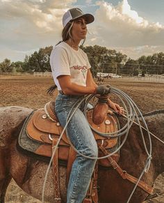 a woman sitting on top of a brown horse