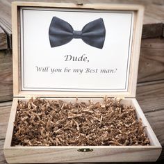 a wooden box filled with wood shavings and a bow tie on the front