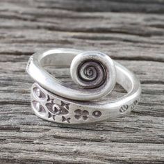 Look deep in to your third eye with this unique hand crafted wrap ring from Thai artisan Achara. This ring's design features an abstract stamping of eye shapes on the crown and floral patterns around the band. The 925 sterling silver band then culminates in to a beautiful oxidized spiral at the crown. Eye Ring Silver, Silver Wrap Ring, Silver Eye, Trendy Earrings, Silver Jewelry Handmade, Sterling Silver Flowers, Wrap Rings, Sterling Silver Bands, Silver Flowers