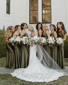 the bride and her bridesmaids are all dressed in olive green dresses with white bouquets