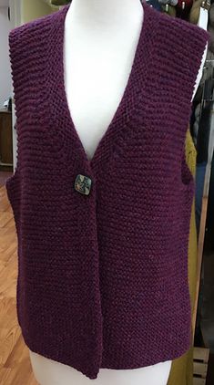 a mannequin wearing a purple knitted vest with buttons on the front and back