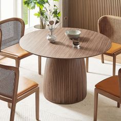 a dining table with chairs around it and a vase on the table next to it