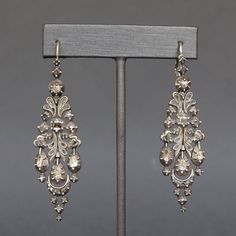 A dramatic and dazzling pair of Catalan drop earrings dating to the early 1800s. Known as 'herring' earrings due to the resemblance of their silhouette to herrings in brine, a popular dish of the region, they are set with a total of 74 diamonds, mainly rose- and table-cuts. The gems are set close-backed, some with crimped collets, and are most likely foiled. Each earring consists of five individually articulated sections which swing with movement and bring sparkle to the diamonds as they catch t Diamond Chandelier Earrings, Diamond Chandelier, Georgian Era, Antique Diamond, Chandelier Earrings, Jewelry Earrings Dangle, Dangle Drop Earrings, Dangle Earrings, Jewelry Earrings