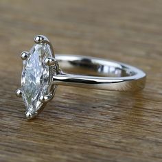 a diamond ring sitting on top of a wooden table