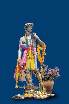 the statue is surrounded by flowers and other items