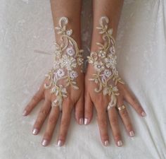 two hands with white and gold lace on them