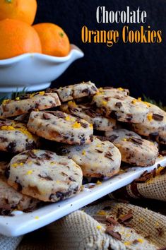 chocolate orange cookies on a white platter with oranges in the background and text overlay