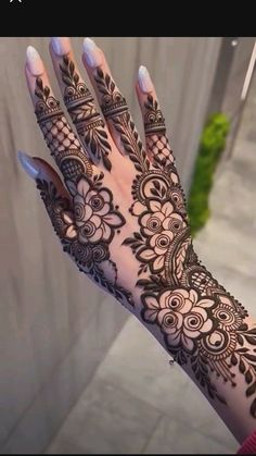 a woman's hand with henna tattoos on it