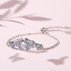 Glistening and glamorous, this bracelet will win your heart. Crafted in sterling silver, it features a shimmering round cut center stone wrapped in sparkling blue stones, bringing out it's beauty and sparkle. Additional stones form butterfly shaped design to add more elegance to this bracelet. This bracelet is a splendid choice you are sure to adore.Carat Weight: 1.5 ctStone Size: 6 mmNumber of Stones: 1 Stone Shape: RoundStone Color: Diamond WhiteCarat Weight: 1.655 ctStone Size: 2.5,1.5,3.5,1. Blue Stones, Stone Wrapping, Butterfly Bracelet, Bracelet Online, Women's Jewelry And Accessories, Butterfly Shape, Sterling Silver Bracelet, Blue Butterfly, Blue Stone