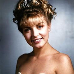 an old photo of a woman with very short hair and blue eyes smiling at the camera